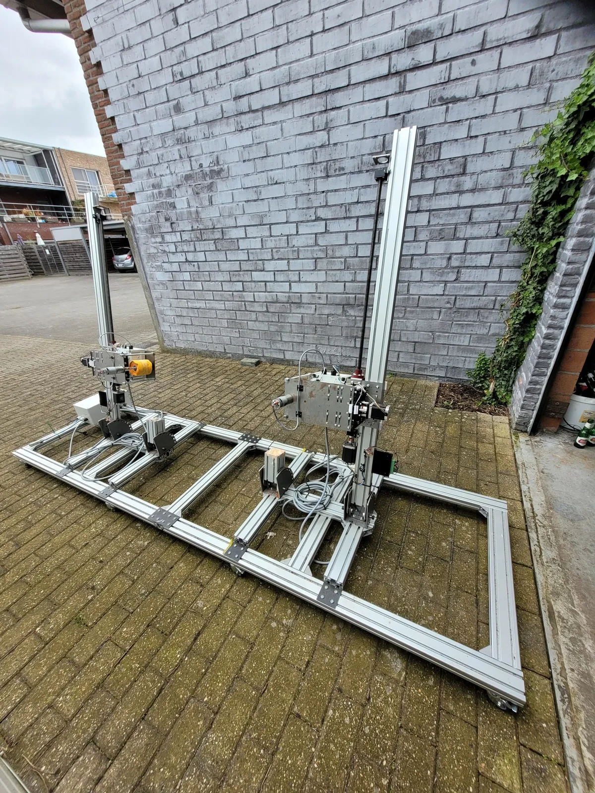 De afrol- en stapelmachine buiten opgesteld, met het aluminium frame, de twee staanders en de stapelkoppen.