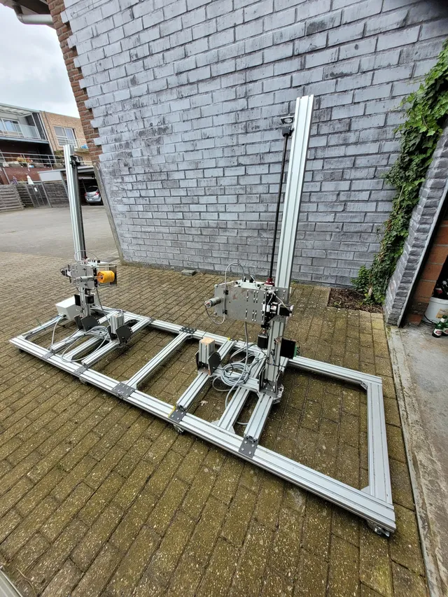 De afrol- en stapelmachine buiten opgesteld, met het aluminium frame, de twee staanders en de stapelkoppen.