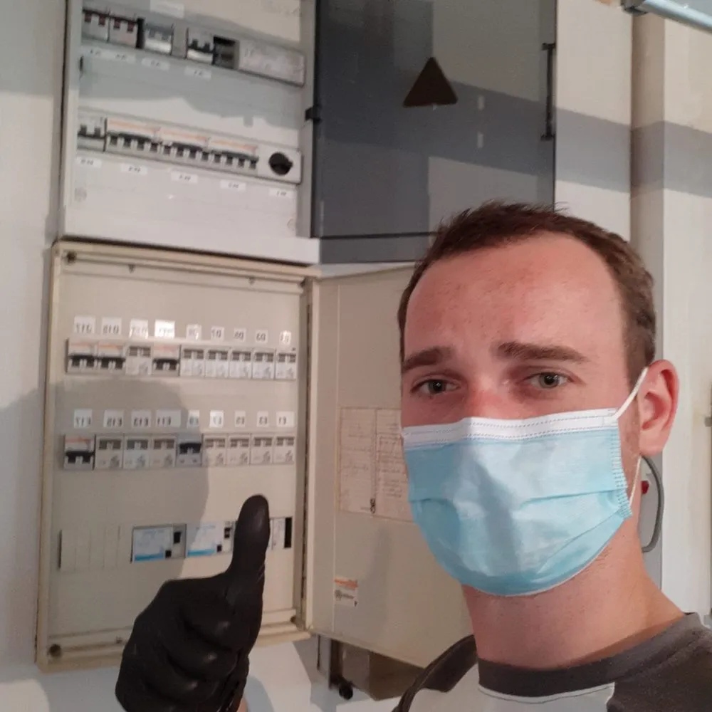 Ward De Lens voor een geopend verdeelbord tijdens een opmeting