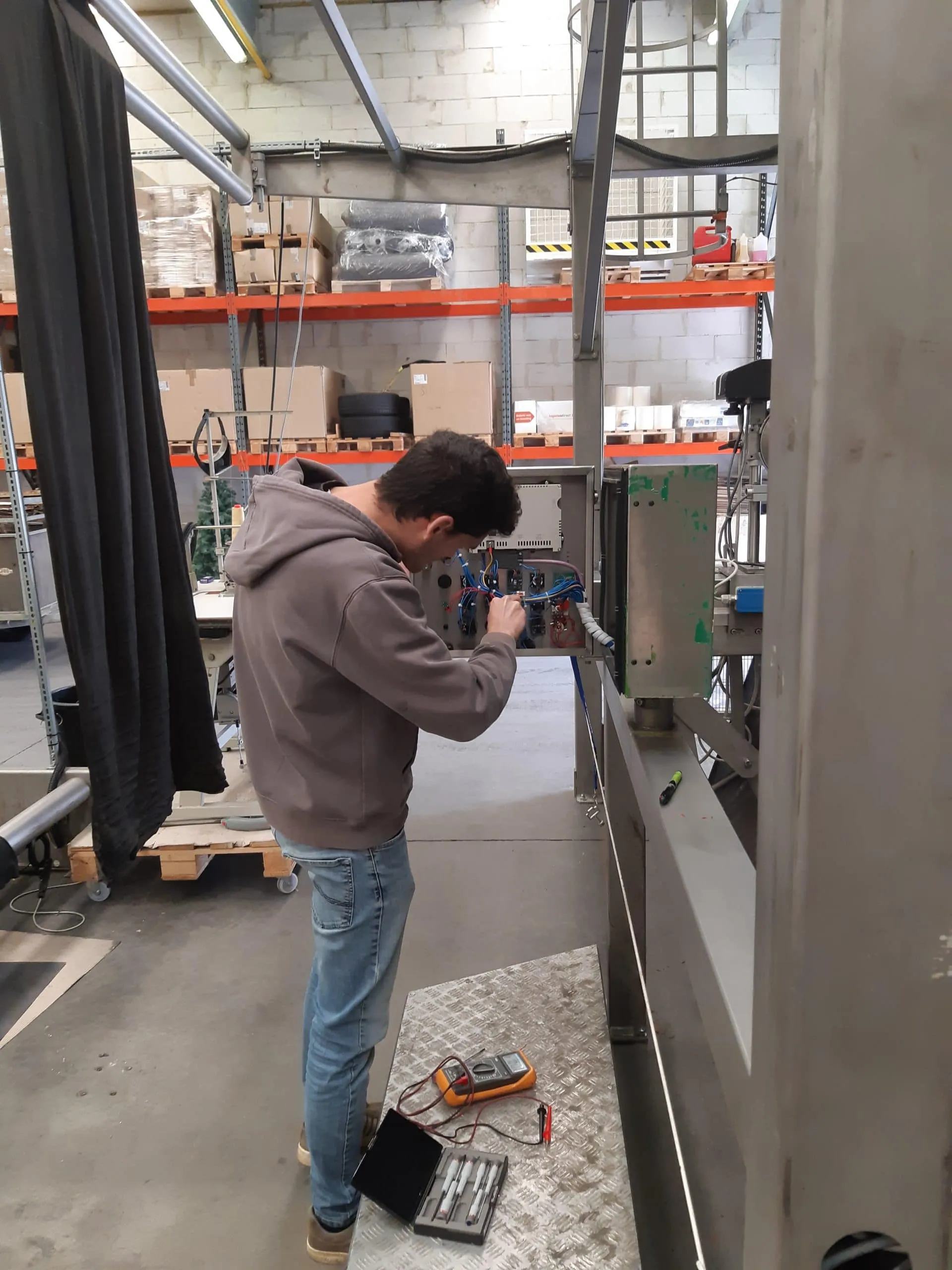 Bart en Ward van ASK Engineering meten een elektrische installatie op aan een open verdeelbord
